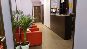 un pasillo de oficinas con dos sillas rojas y plantas en Hostal Corazón de Madrid, en Madrid