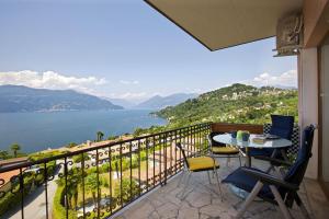 a balcony with a table and chairs and a view of the water at Parco Belmonte in Brezzo