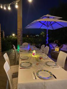 un tavolo con una tovaglia bianca e un ombrello di BREATHTAKING VIEW OF Salento- a Leporano