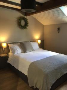 a bedroom with a large bed with white sheets at Maison Vigneronne in Villeneuve-de-Duras