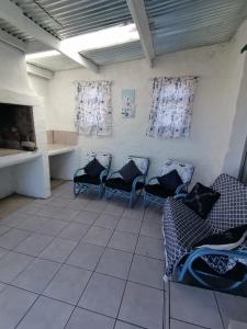 una sala d'attesa con sedie e camino di Arniston Cottage a Arniston