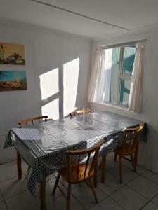 jadalnia ze stołem i krzesłami oraz oknem w obiekcie Arniston Cottage w mieście Arniston
