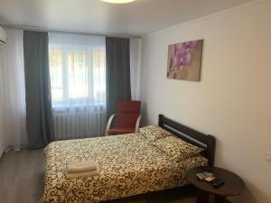 1 dormitorio con 1 cama, 1 silla y 1 ventana en Апартаменты метро Тараса Шевченко en Kiev