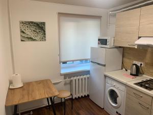 a kitchen with a white refrigerator and a table at Апартаменты метро Тараса Шевченко in Kyiv +11 photos