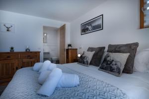 um quarto com uma grande cama branca com almofadas azuis em Yeti Lodge Chalets & Apartments em Chamonix-Mont-Blanc