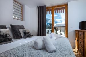 Schlafzimmer mit einem weißen Bett und einem Fenster in der Unterkunft Yeti Lodge Chalets & Apartments in Chamonix-Mont-Blanc