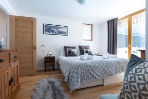 ein weißes Schlafzimmer mit einem Bett und einem Fenster in der Unterkunft Yeti Lodge Chalets & Apartments in Chamonix-Mont-Blanc