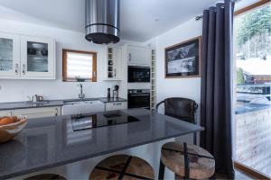 une cuisine avec un comptoir noir et une fenêtre dans l'établissement Yeti Lodge Chalets & Apartments, à Chamonix-Mont-Blanc