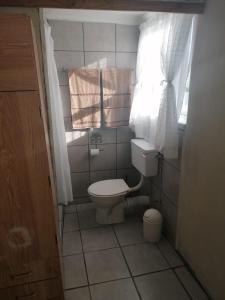 bagno con servizi igienici, finestra e asciugamani di Arniston Cottage a Arniston