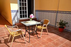 a table with two chairs and a vase with flowers on it at Apartamentos Casa Junonia in Alajeró