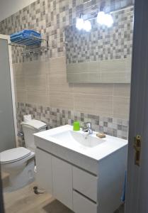 a bathroom with a white sink and a toilet at Apartamentos Casa Junonia in Alajeró