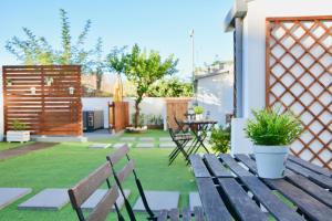 Un jardín con un banco de madera y una mesa. en Porto Garden Villas | Downtown, en Vila Nova de Gaia
