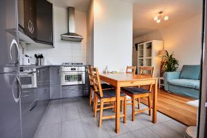 Il comprend une cuisine avec une table et des chaises en bois. dans l'établissement Treehouse Inn, à Duivendrecht