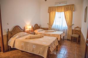 um quarto de hotel com duas camas e uma janela em Alojamento Local Familiar em Monfortinho