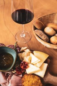 une assiette de fromage et de viande et un verre de vin dans l'établissement Hotel Aurora, à Arco