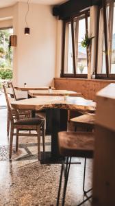 um quarto com mesas e cadeiras de madeira e janelas em Hotel Aurora em Arco