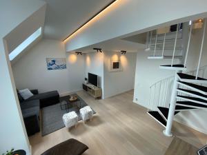 een witte woonkamer met een trap en een woonkamer bij Coxy Penthouse Koksijde in Koksijde