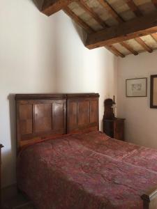 ein Schlafzimmer mit einem großen Holzbett in einem Zimmer in der Unterkunft Casale del monte, Pesaro in Pesaro