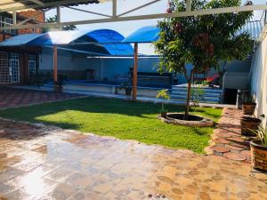 einen Innenhof mit einem Garten mit einem Baum und Sonnenschirmen in der Unterkunft Casa el paraíso in Oaxtepec