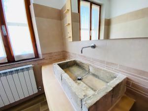 um lavatório de pedra antigo numa casa de banho com um espelho em Agriturismo Casa Orsini em Montefalco