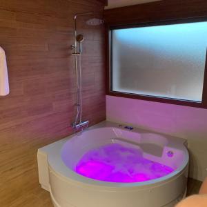 a bathroom with a tub filled with pink water at Casa rural Alcala Cabaña Del herrero in Alcalá del Júcar