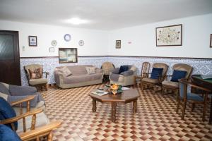 uma sala de estar com sofás e cadeiras e uma mesa em Alojamento Local Familiar em Monfortinho