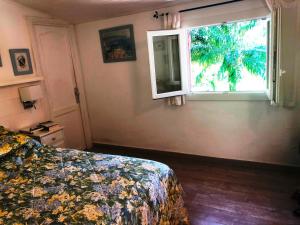 - une chambre avec un lit et une fenêtre dans l'établissement Les deux mas, à Bormes-les-Mimosas