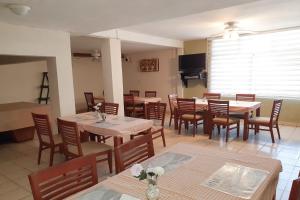 comedor con mesas y sillas y TV en Hotel Casa Blanca, en Celaya