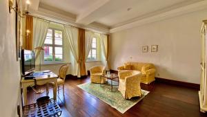 ein Wohnzimmer mit einem Sofa, Stühlen und einem Tisch in der Unterkunft Hotel Graf von Mansfeld in Lutherstadt Eisleben