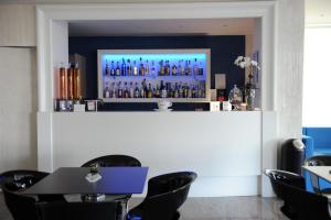 un bar in un ristorante con tavoli e sedie neri di Hotel Altis a San Benedetto del Tronto