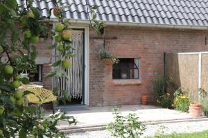 een stenen huis met een deur en een raam bij Kade10Buren in Buren