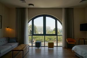 a living room with a couch and a large window at Apartique Hotel in Jerusalem