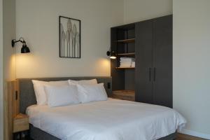 a bedroom with a white bed with a black cabinet at Apartique Hotel in Jerusalem