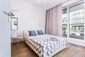 - une chambre blanche avec un lit et une fenêtre dans l'établissement ResiNest Apartamenty Butikowa Kamienica M40, à Białystok