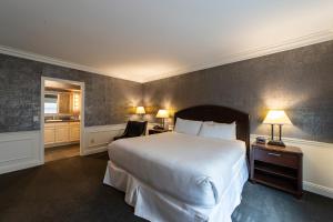 a hotel room with a large bed and two lamps at The Grand Resort in Howland Corners