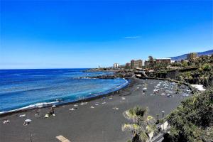 a beach with a crowd of people and the ocean at Holiday home Los Frailes in Puerto de la Cruz