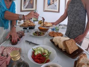 a group of people standing around a table with food at The Maltese Sun in Sliema