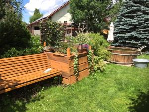 un banco de madera sentado en el césped en un patio en Die Dirndlkönigin, en Grünenbach