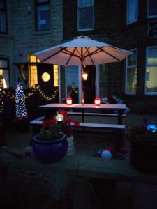a picnic table with an umbrella in front of a house at Captains Lodge in Newbiggin-by-the-Sea