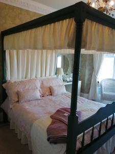 a bedroom with a large bed with a canopy at Captains Lodge in Newbiggin-by-the-Sea +41 photos