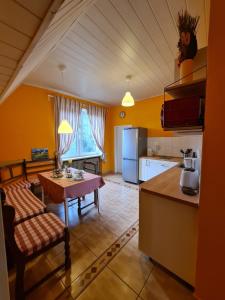 eine Küche mit einem Tisch und eine Küche mit gelben Wänden in der Unterkunft Bei Chogman in Gronau + 22 Fotos