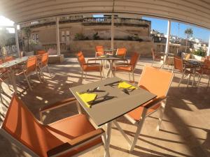 a patio with tables and chairs on a roof at The Maltese Sun in Sliema