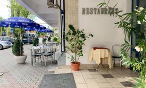 een restaurant met een tafel en stoelen en een parasol bij Hotel Decebal Bistrita in Bistriţa