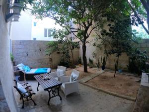 a patio with a table and chairs and a tree at The Maltese Sun in Sliema