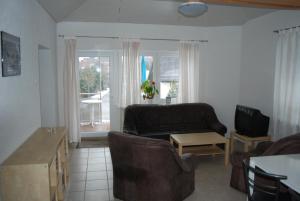 ein Wohnzimmer mit einem Sofa und einem Tisch in der Unterkunft Ferienwohnungen Schäfer in Obersulm
