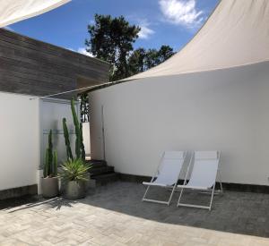 un patio con 2 sillas y una mesa junto a una pared en Morada Do Pablinho en Isla de Arosa