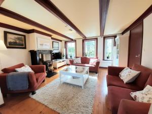 Sala de estar con 2 sofás y mesa en Winsum - Groningen - 6 pers. Cosy Cottage - Op en Bie t Woater, en Winsum