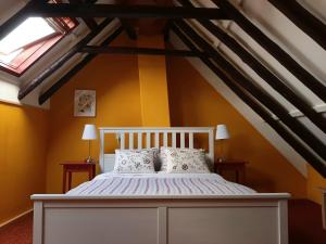 ein Schlafzimmer mit einem weißen Bett im Dachgeschoss in der Unterkunft Winsum - Groningen - 6 pers. Cosy Cottage - Op en Bie t Woater in Winsum