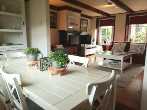 een woonkamer met een witte tafel en stoelen bij Winsum - Groningen - 6 pers. Cosy Cottage - Op en Bie t Woater in Winsum