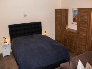 a bedroom with a black bed and a couch at 146 Suedstrand Meerblick in Wilhelmshaven +14 photos